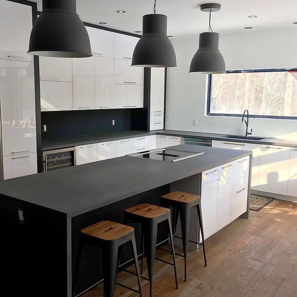 Modern black and white kitchen with black countertop and stools Modern black and white kitchen with black countertop and stools