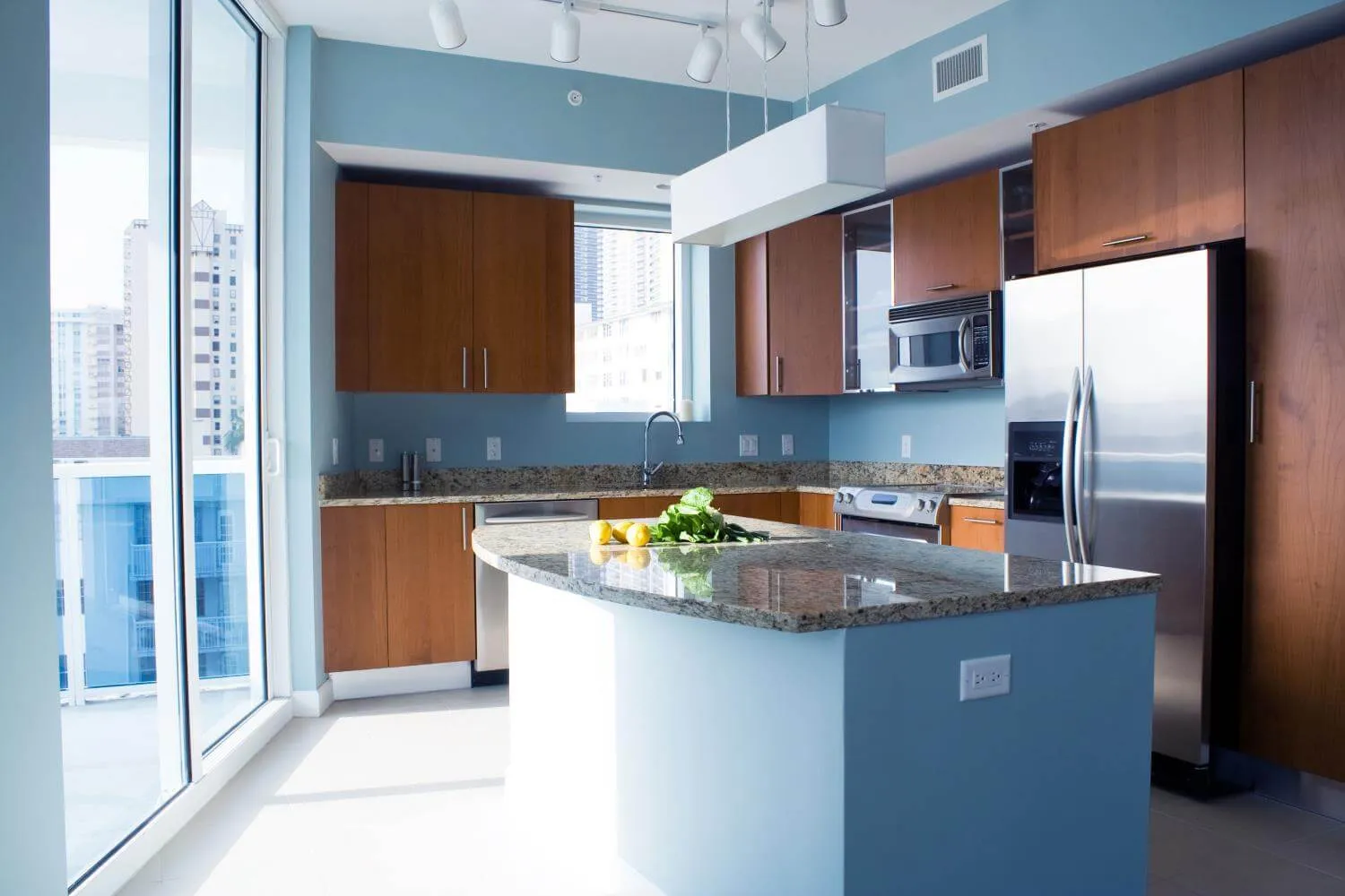 Modern wood cabinet kitchen with light blue walls and island Modern wood cabinet kitchen with light blue walls and island