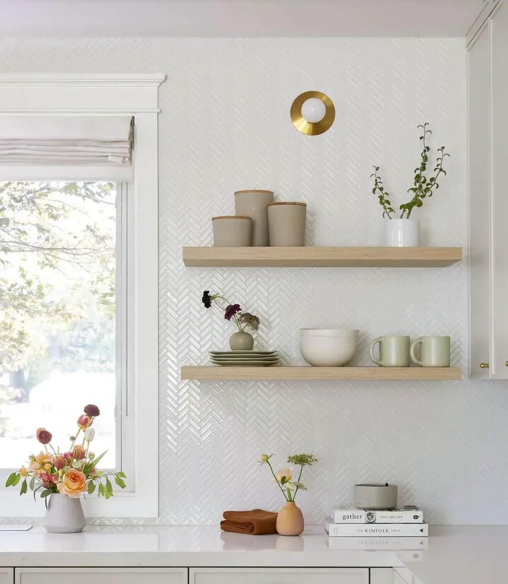 Simple open shelving with bowls cups and decor on a white wall Simple open shelving with bowls cups and decor on a white wall