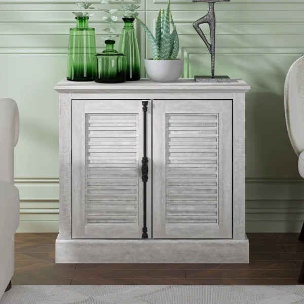 Small white cabinet with decor in a living room setting Small white cabinet with decor in a living room setting