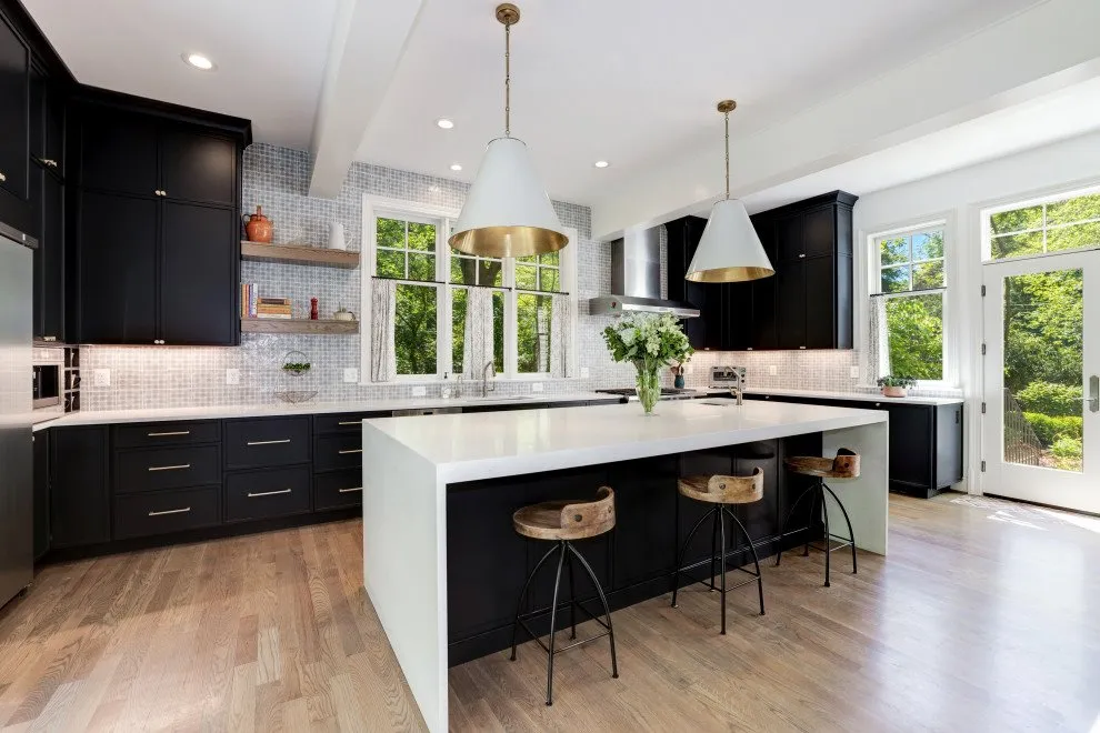 Spacious kitchen with black cabinets and large white island Spacious kitchen with black cabinets and large white island