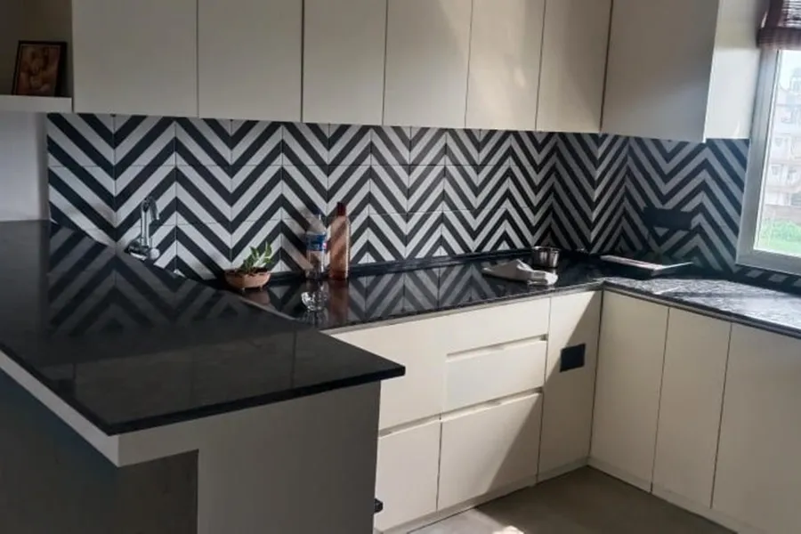 White cabinets with a bold chevron patterned backsplash design White cabinets with a bold chevron patterned backsplash design