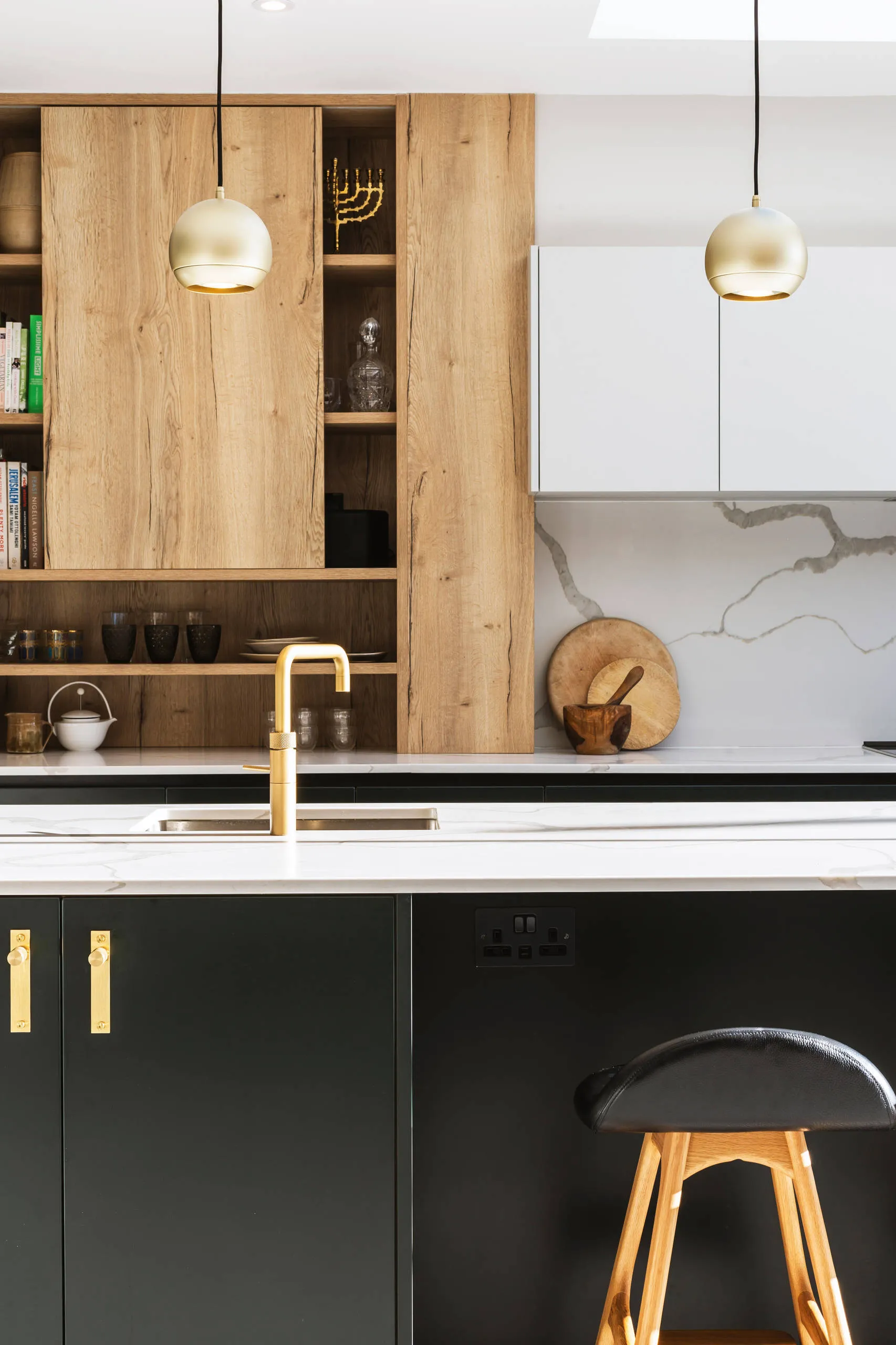 Wooden and black kitchen island with hanging gold lights Wooden and black kitchen island with hanging gold lights