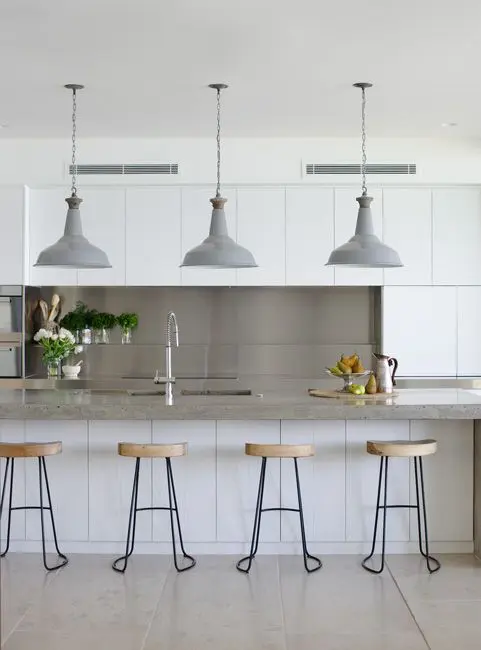clean kitchen with white cabinets and wooden bar stools featuring hanging industrial pendant lights