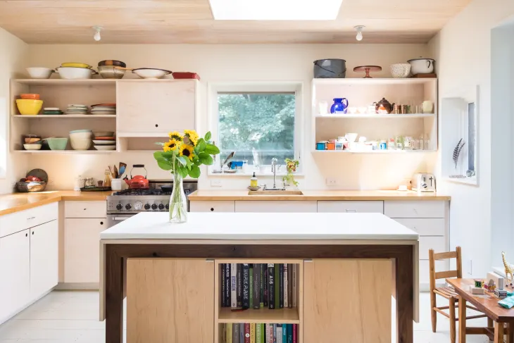 open kitchen cabinets with a flower on the desk