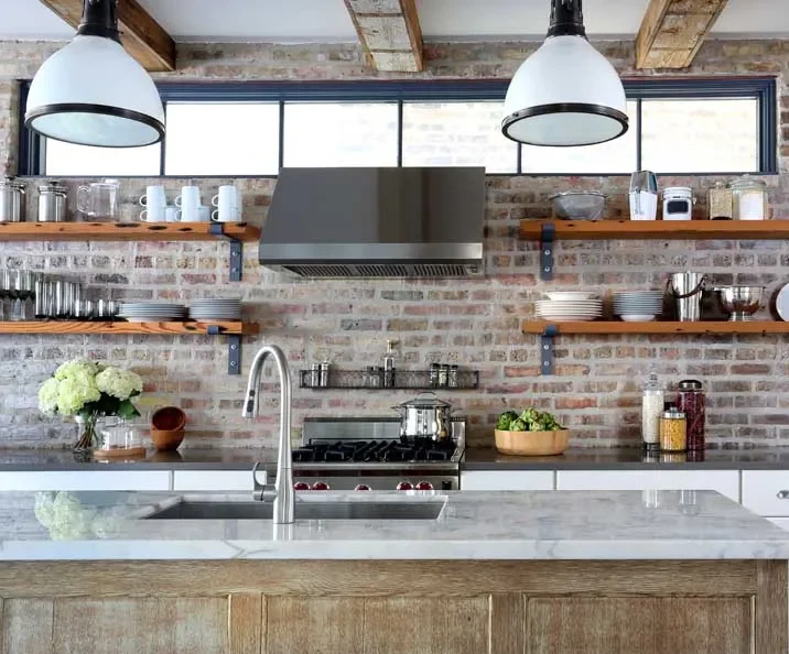 open kitchen cabinets with exposed brick as a backdrop