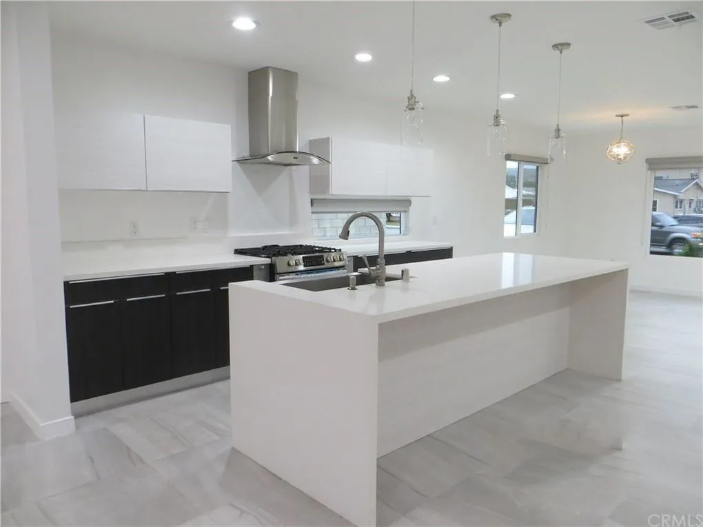 Black cabinets with marble countertops in a modern kitchen Minimalist black and white kitchen with long central island