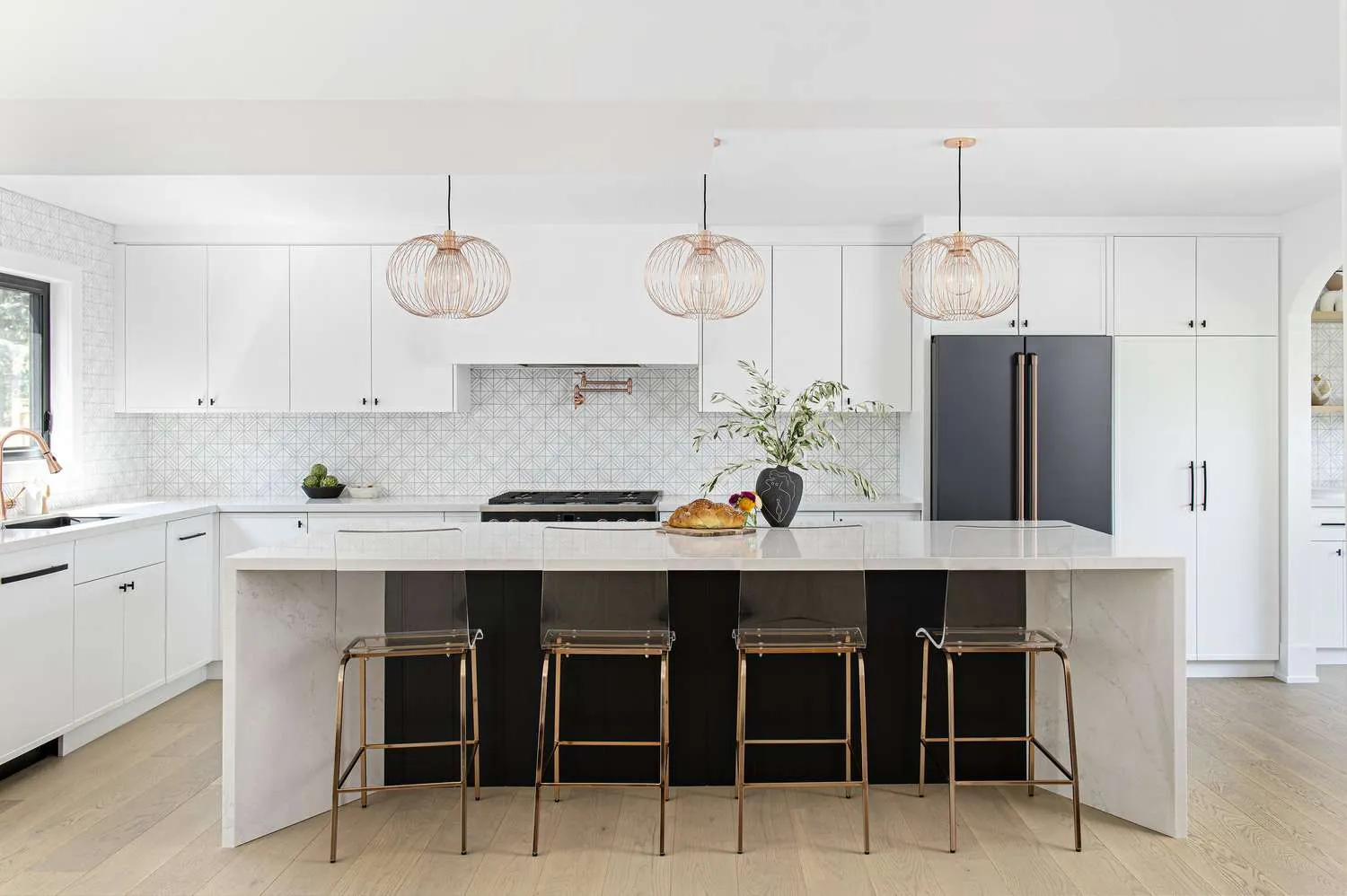 Spacious kitchen featuring black island and white cabinetry Modern Black and White Cabinets Accent Lighting