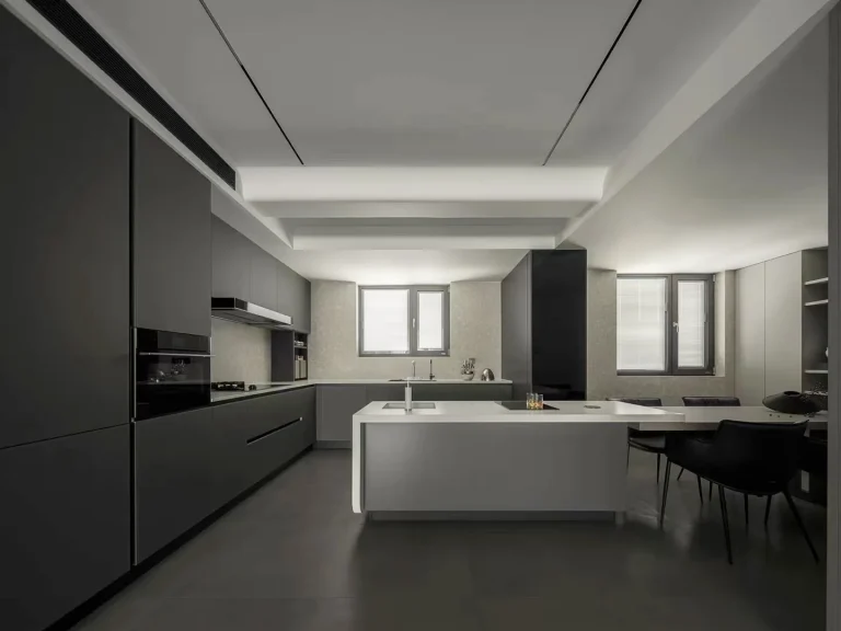Modern dark kitchen with sleek cabinets and white island countertop