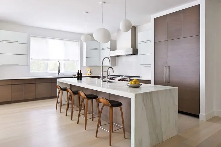 Contemporary kitchen with a sleek white waterfall island and stools Contemporary kitchen with a sleek white waterfall island and stools