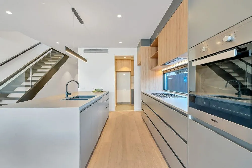 Cozy galley kitchen with dark cabinetry and natural light