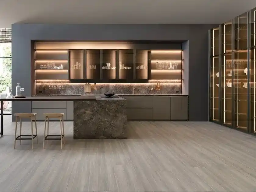 Elegant taupe kitchen featuring illuminated shelves stone island and wooden stools Elegant taupe kitchen featuring illuminated shelves stone island and wooden stools