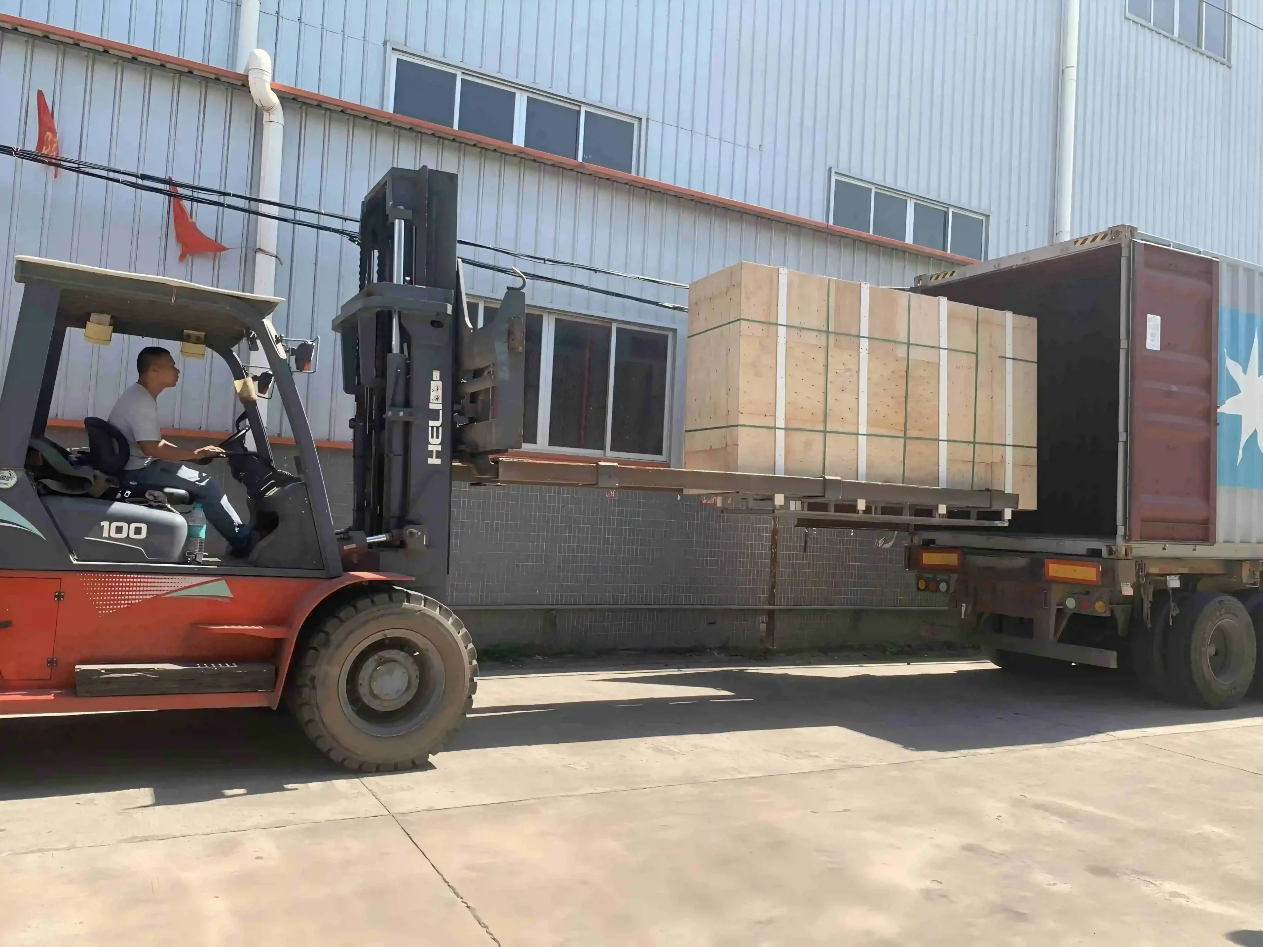 Forklift loading a large crate onto a truck
