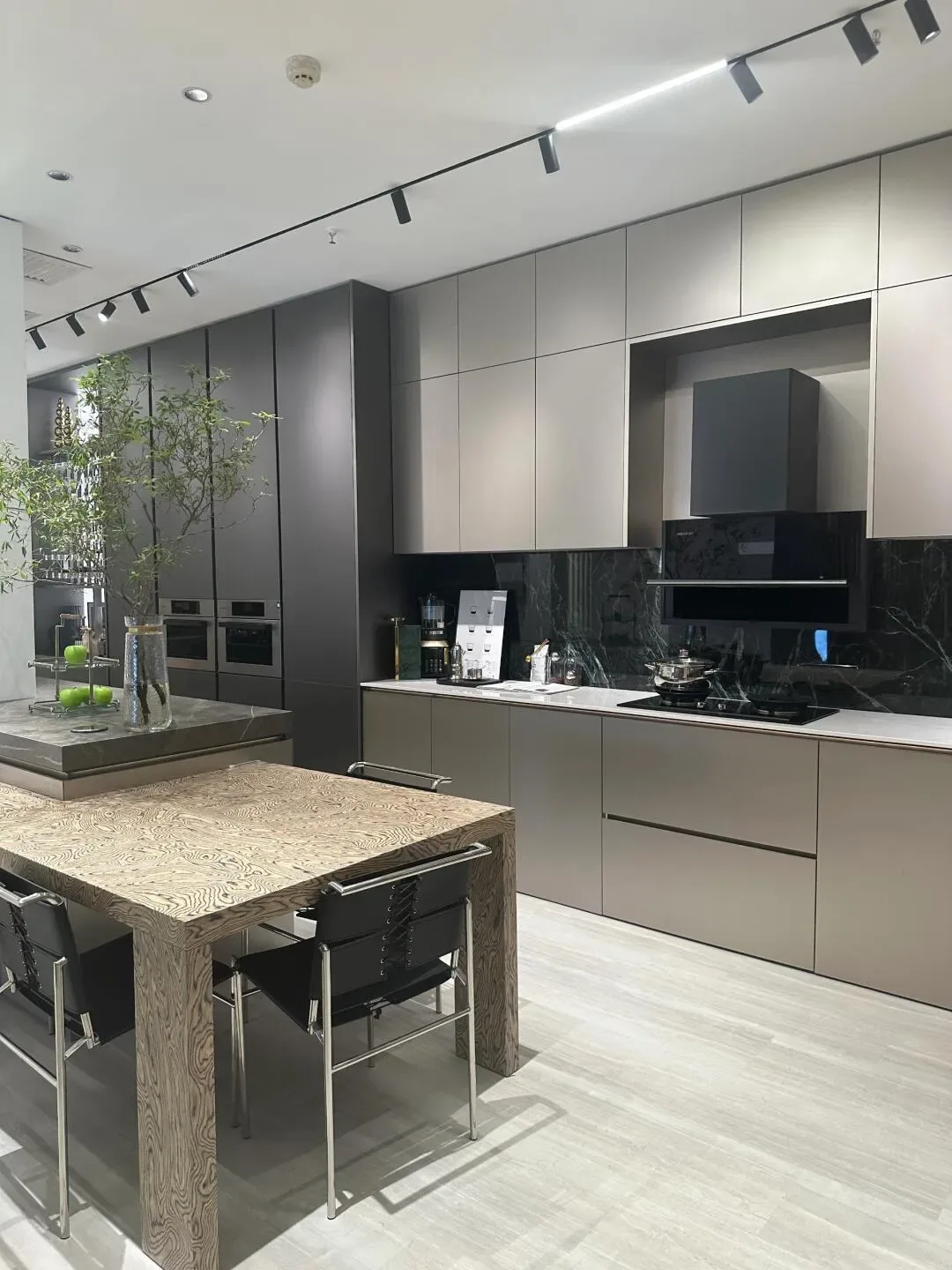 Modern kitchen with wooden table and sleek cabinets in gray tones Modern kitchen with wooden table and sleek cabinets in gray tones