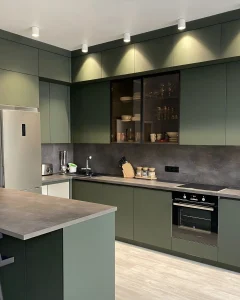 Sleek green cabinetry paired with minimalist countertops and a black stove