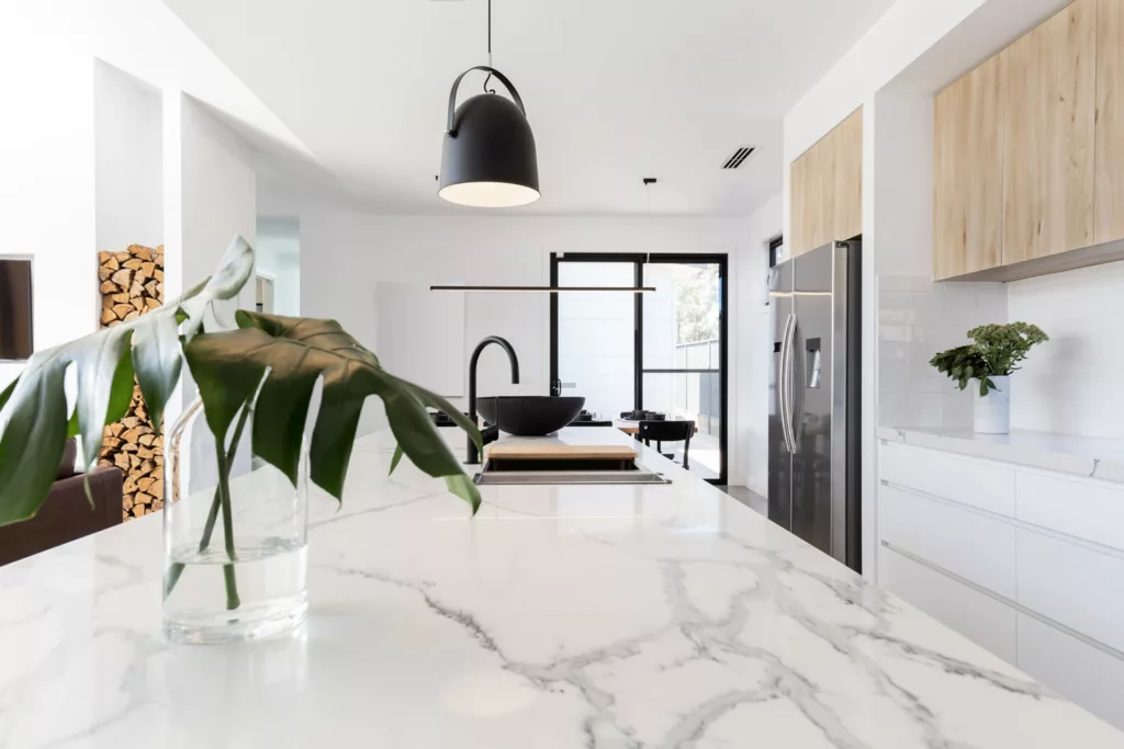 Stylish kitchen with a marble waterfall island and wood details Stylish kitchen with a marble waterfall island and wood details