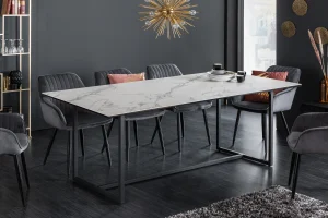 White marble table with sleek black legs and velvet chairs