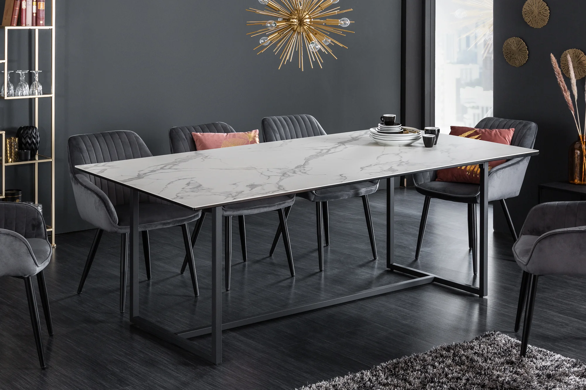 White marble table with sleek black legs and velvet chairs