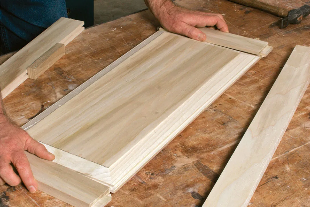A man is focused on shaping a piece of wood with tools in a workshop setting kitchen A man is focused on shaping a piece of wood with tools in a workshop setting kitchen