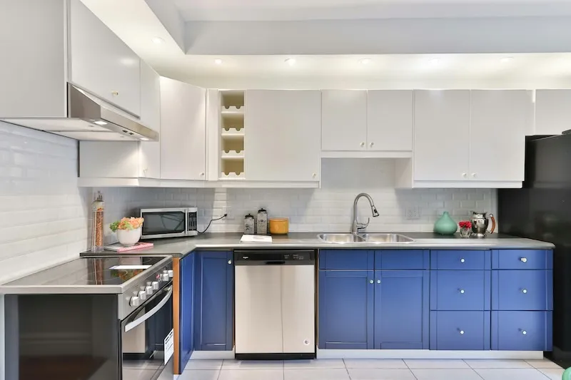 Blue and white kitchen cabinets with modern appliances