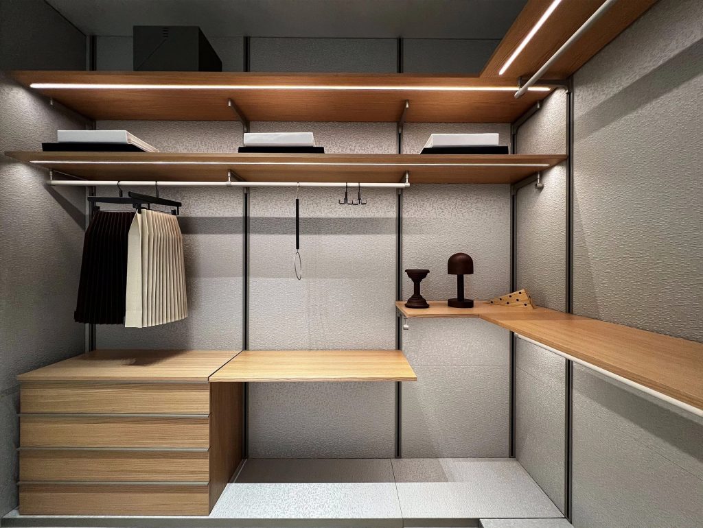 Open walk-in wardrobe with wooden shelves and drawers