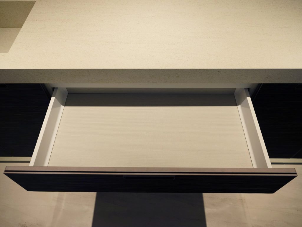 Close-up of European kitchen cabinet drawer with storage.